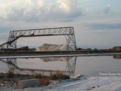 Percorriamo la strada provinciale 141, arteria che solca il pezzo di terraferma frapposto tra le enormi �piscine� e il mare. Subito veniamo rapiti dalle montagne di sale...